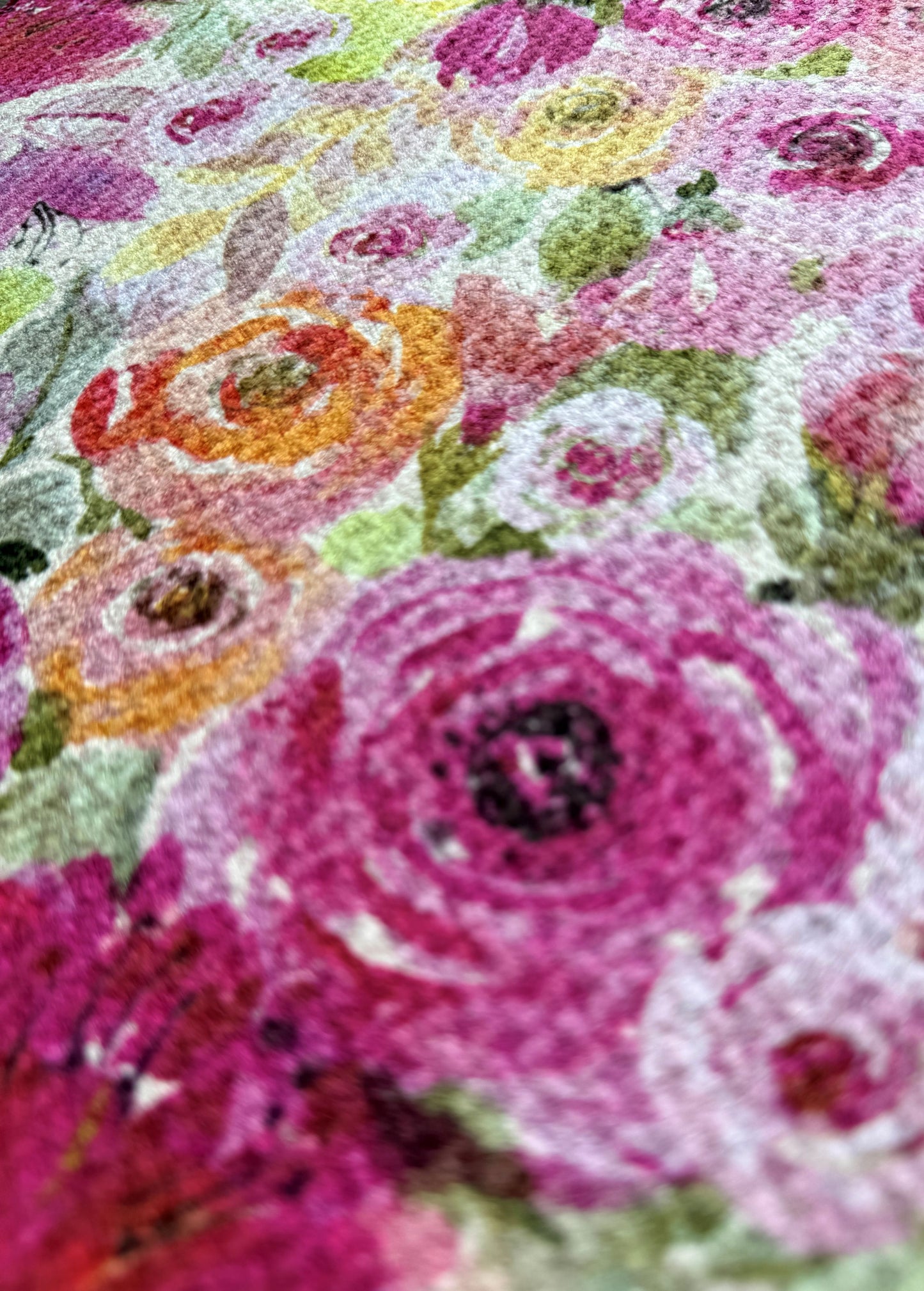 Close-up of a floral pattern tea towel with pink, orange, and green colors.