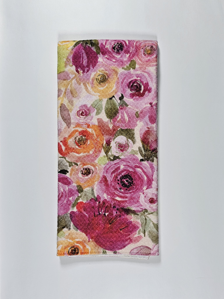 Floral patterned towel with pink, orange, and green flowers on a white background