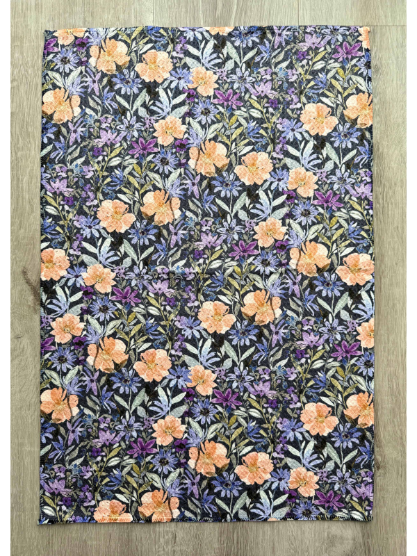 Floral patterned fabric with orange and purple flowers on a wooden surface
