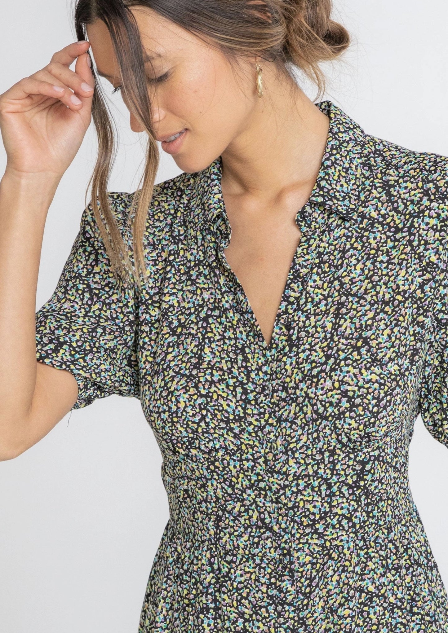 Woman wearing a floral dress against a plain background