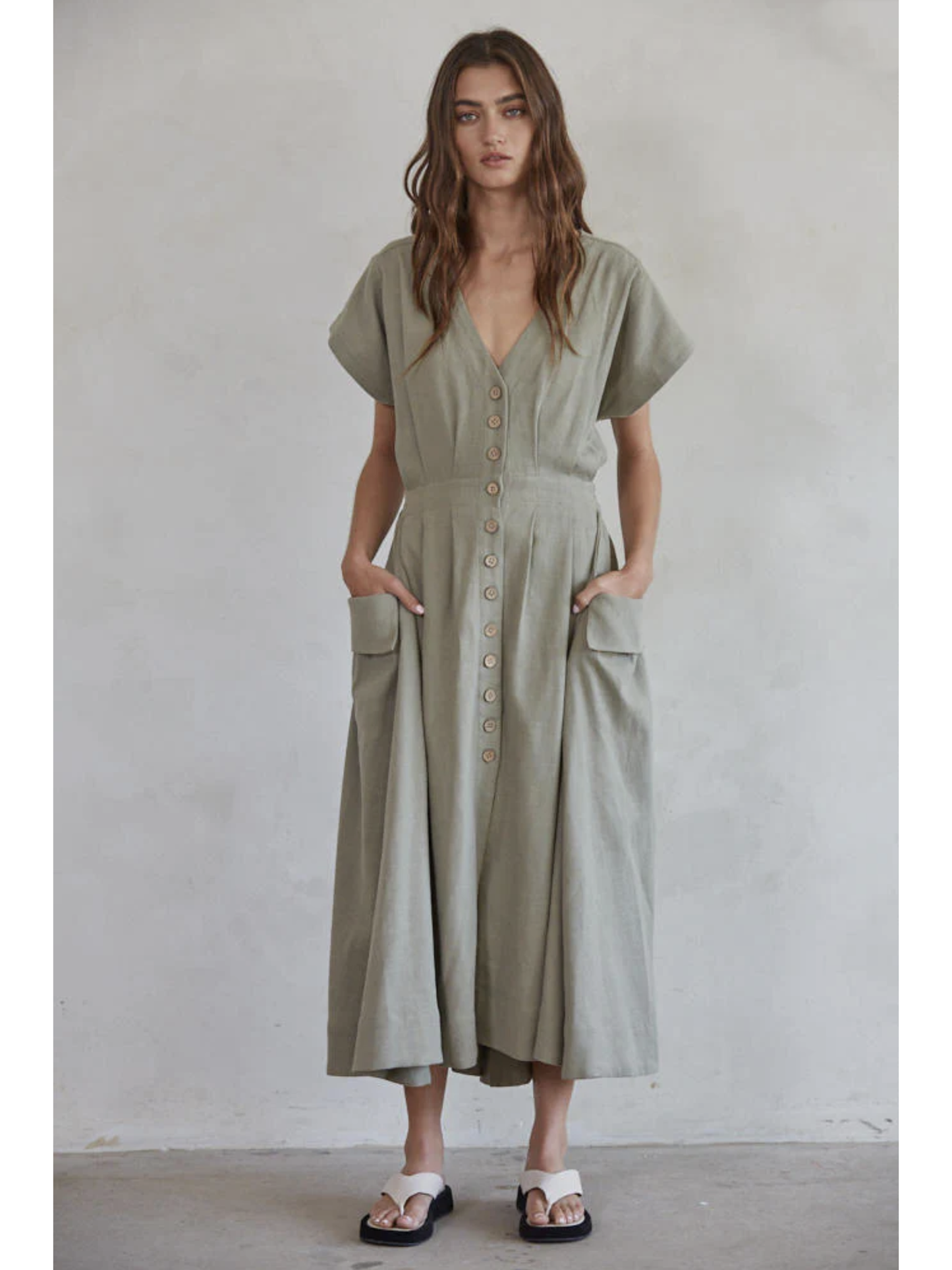 Woman wearing a green dress against a plain background