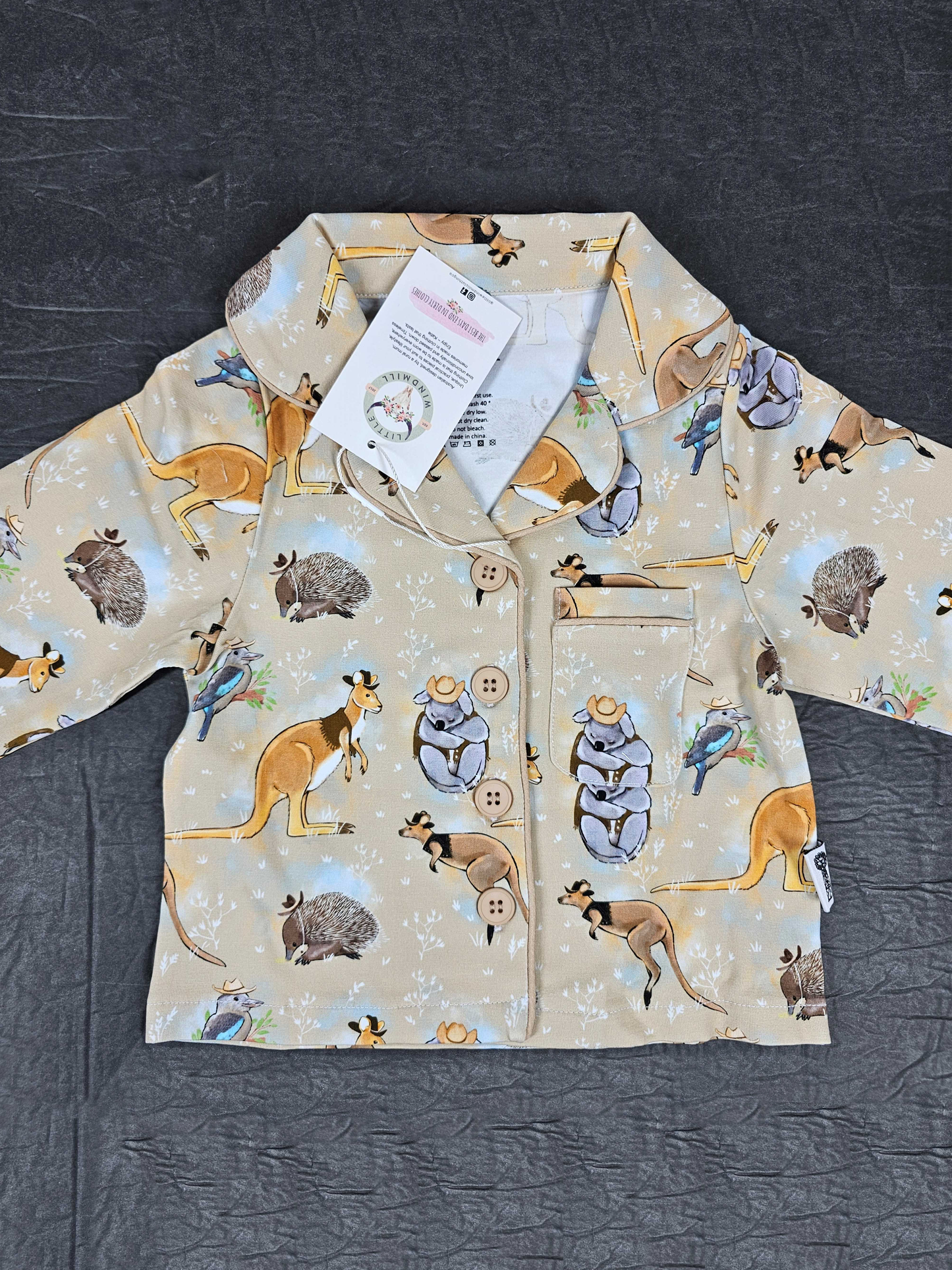 Children's pajamas top with animal pattern on a dark surface
