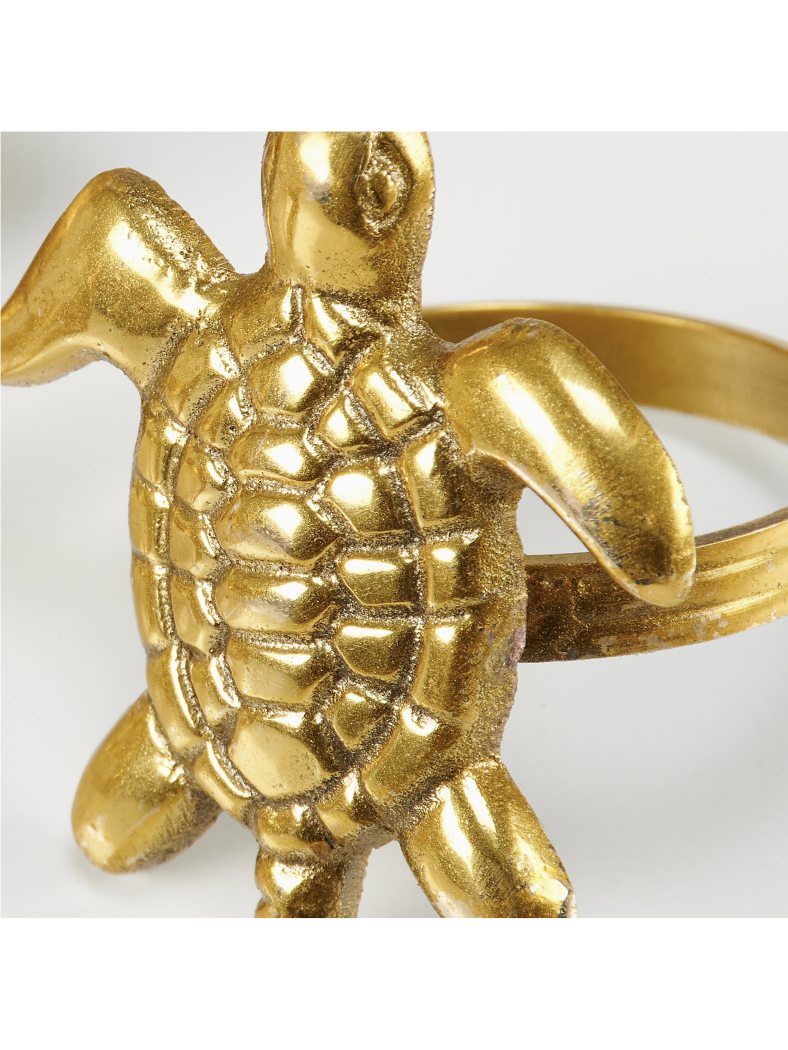 Gold turtle-shaped ring on a white background
