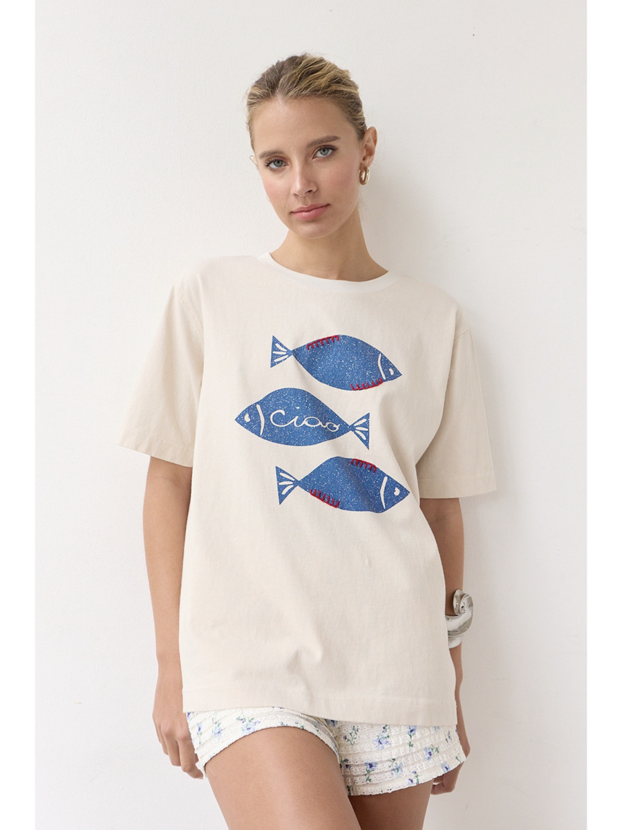 Artisanal t-shirt featuring a whimsical fish graphic with unique stitch details on a soft-wash fabric for a soulful, coastal, slow-living aesthetic