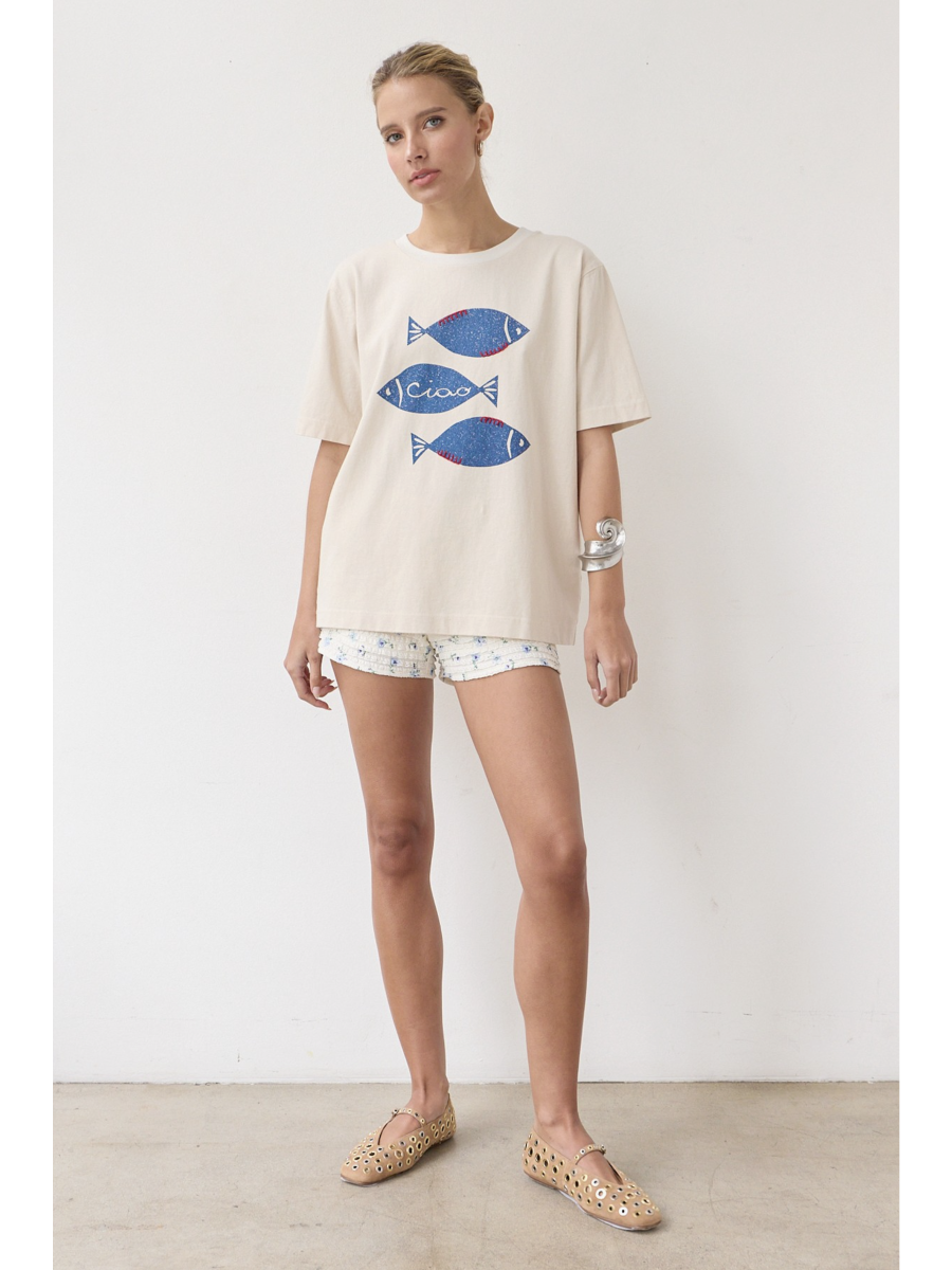 Artisanal t-shirt featuring a whimsical fish graphic with unique stitch details on a soft-wash fabric for a soulful, coastal, slow-living aesthetic