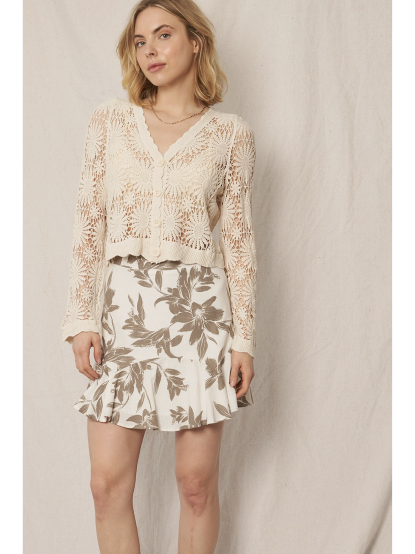 Model wearing a cream open-knit crochet cardigan with a floral sunburst pattern, scalloped edges, and long lace sleeves.