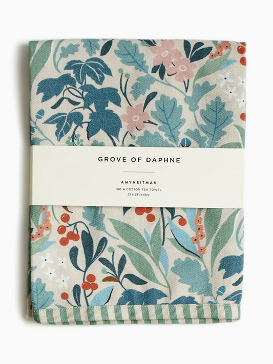 Whimsical watercolor tea towel featuring the 'Grove of Daphne' botanical print with lush green leaves and delicate flowers.