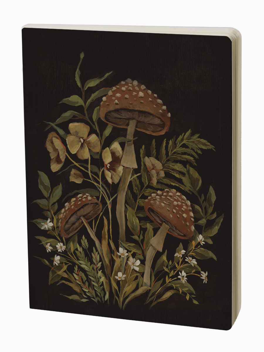 Hidden Garden Journal with dark covers featuring whimsical mushroom and flower illustrations with ferns and small white blooms.