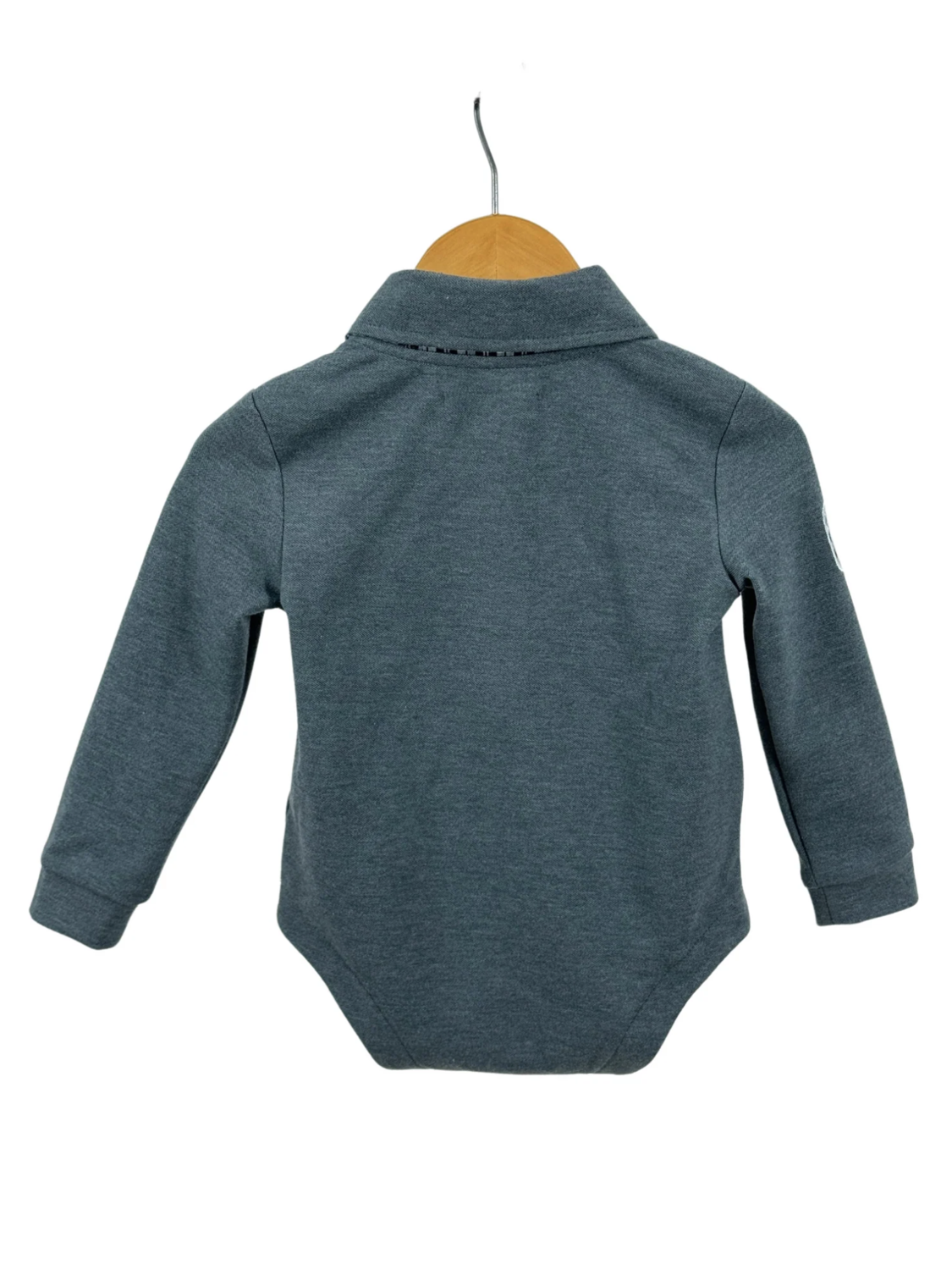 Gray baby bodysuit on a hanger with a white background