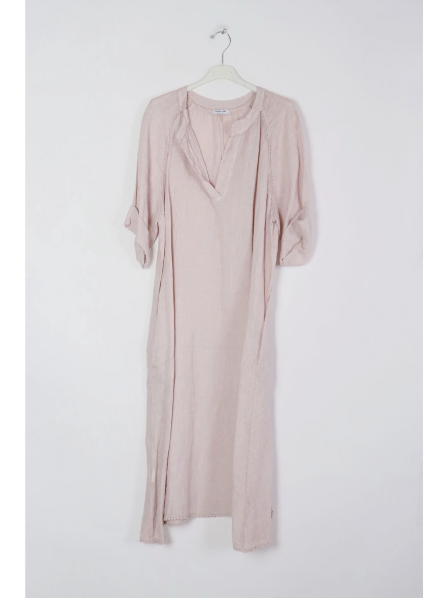 Pink dress on a hanger against a white background