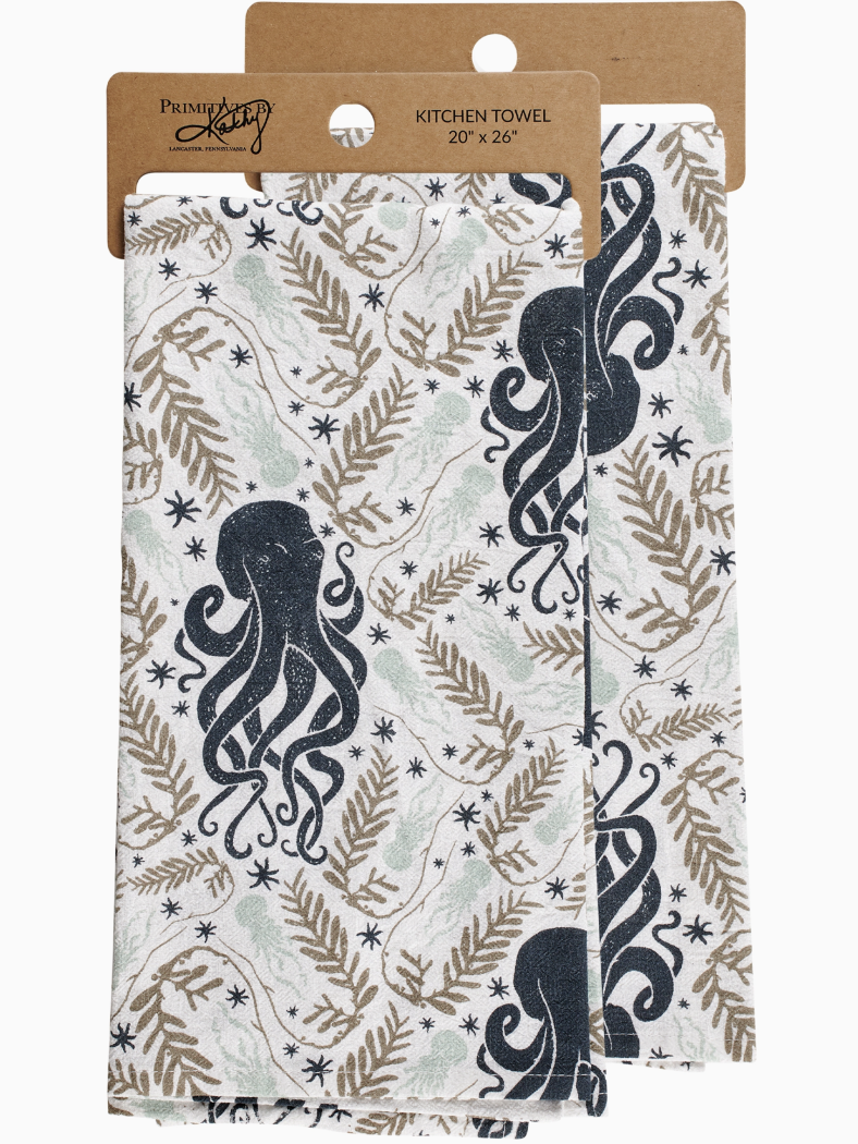White kitchen towel with a repeating pattern of dark blue octopuses, tan seaweed fronds, and small black stars.