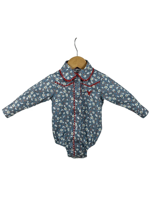 Floral baby romper with red trim on a white background