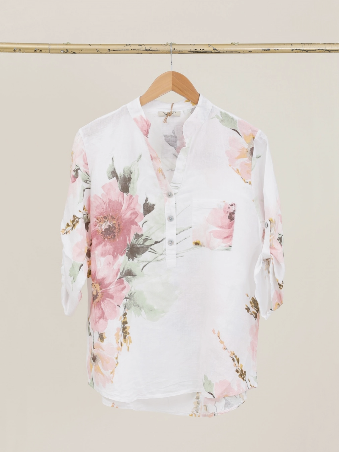 Floral blouse on a hanger against a beige wall