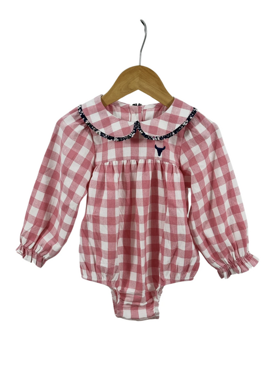 Pink and white gingham long-sleeve baby romper featuring a floral-trimmed Peter Pan collar and ruffled cuffs on a wooden hanger.
