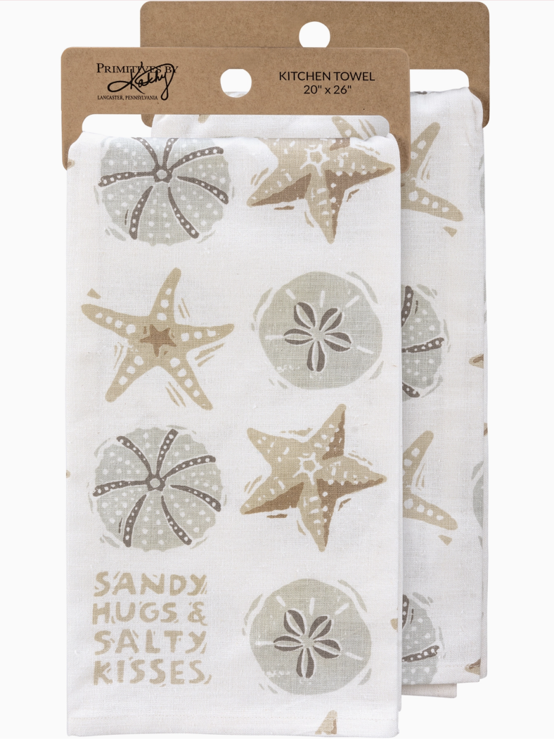 White kitchen towel with tan starfish and sand dollar illustrations and the text "Sandy Hugs & Salty Kisses" in the corner.