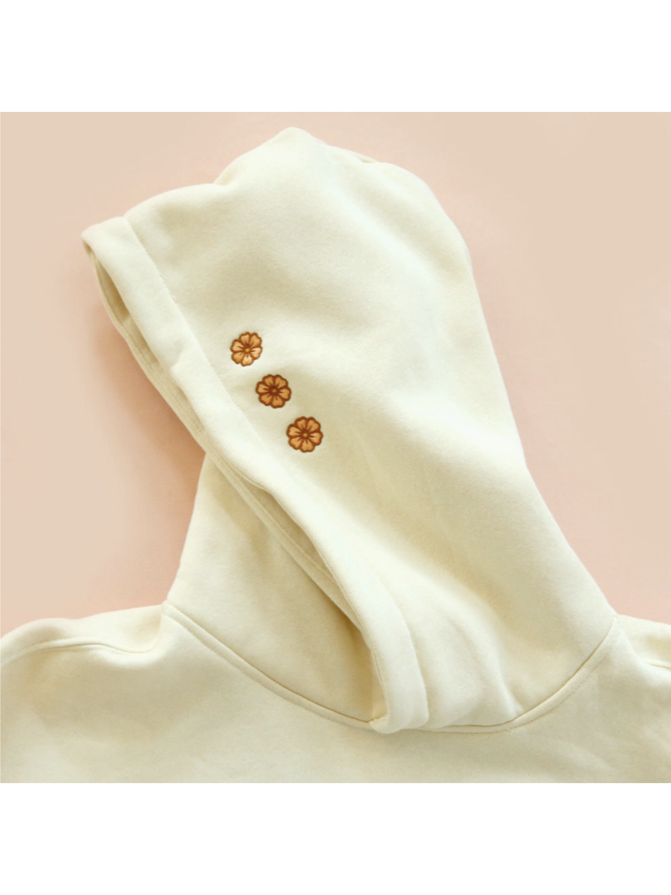 Cozy hoodie featuring a detailed embroidery of a coastal sunset over waves, designed for a whimsical and relaxed slow-living aesthetic.
