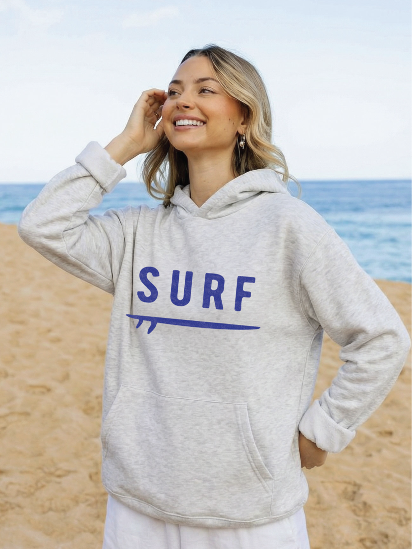 Cozy pullover hoodie with a whimsical surf graphic, featuring a soft-brushed texture and a relaxed, soulful coastal aesthetic.