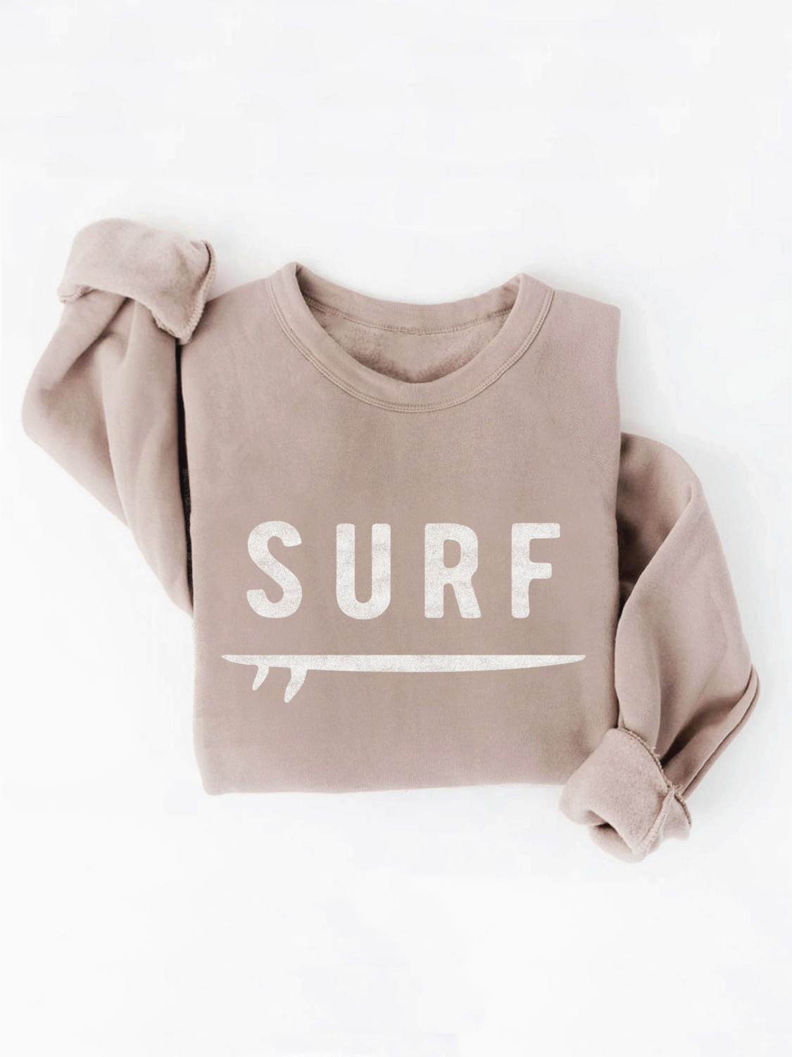 Mineral-washed tan sweatshirt with white "SURF" text and surfboard graphic, folded on a white background.