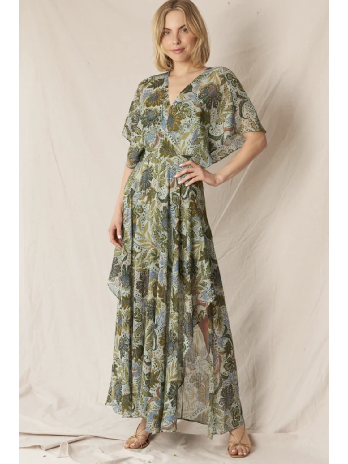 Model in a dark floral print gauze maxi dress with a V-neckline, long sleeves, and a tiered skirt, standing against a neutral background.
