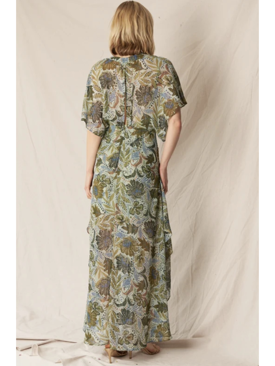 Model in a dark floral print gauze maxi dress with a V-neckline, long sleeves, and a tiered skirt, standing against a neutral background.