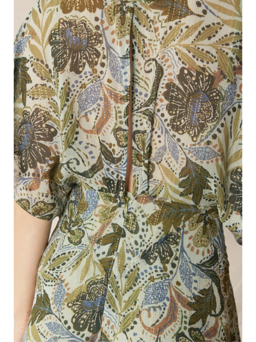 Back detail of Model in a dark floral print gauze maxi dress with a V-neckline, long sleeves, and a tiered skirt, standing against a neutral background.